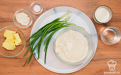 Возьмите муку и просейте ее дважды в чистую глубокую миску. Выньте молоко из холодильника, чтобы оно было комнатной температуры. Вода тоже не должна быть холодной. В сотейнике или маленькой кастрюльке растопите сливочное масло. Влейте в него растительное и перемешайте. Оставьте остывать до теплого состояния. Измельчите зеленый лук ножом или в кухонном комбайне, предварительно помыв его.