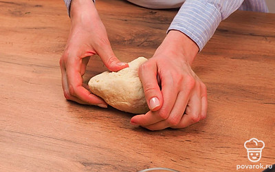 Начните готовить слоеные лепешки. Возьмите муку и добавьте в нее соль. Перемешайте. Сделайте в смеси небольшую ямку и влейте в нее молоко и воду. Перемешайте сначала ложкой, а затем руками. Выложите тесто прямо на стол и месите 5 минут. Оставьте отдыхать на полчаса при комнатной температуре.