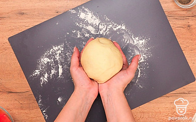 Приступите к замешиванию теста. Слегка подогрейте воду и добавьте в нее масло, чеснок и соль. Засыпьте пищевую соду со щепоткой лимонной кислоты или пекарский порошок. Постепенно добавляя муку, замешайте мягкое тесто, которое не липнет к рукам. Затем скатайте тесто в шар, поместите в миску и дайте ему «отдохнуть» 10 минут, накрыв миску крышкой. Затем продолжите замешивать тесто, досыпая муки. Когда тесто будет мягким и перестанет прилипать к рукам оберните тесто пленкой и оставьте на 10 минут.