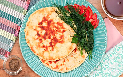 Готовые лепешки сложите на тарелку. Их можно подавать со свежими овощами или вместо хлеба к первому блюду. Оставшиеся лепешки долго пролежат в холодильнике. А если подсохнут, то их можно "оживить", сбрызнув водой и отправив в пакете на холод.