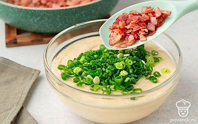 Мелко нарежьте бекон и обжарьте его на среднем огне до образования корочки. Выложите бекон в миску к смеси, добавьте мелко нарезанный зеленый лук. Хорошо перемешайте готовое тесто, оно должно быть густым и не растекаться. 