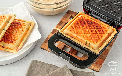 Ложкой выложите тесто в вафельницу, закройте крышкой и готовьте 5-8 минут. Готовые вафли выложите на бумажное полотенце, чтобы оно впитало лишнюю влагу, а вафли не размокли и остались хрустящими. 