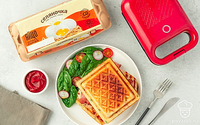 Выложите вафли и сыр на тарелку для подачи. Дополните блюдо жареным беконом, свежим шпинатоми и нарезкой из овощей. А с томатным соусом завтрак станет еще вкуснее и ароматнее. 