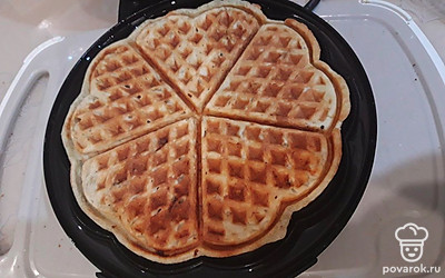 Уберите готовые вафли, смажьте вафельницу маслом, выложите новую порцию теста.