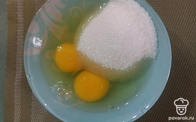 Вбейте 2 яйца и положите полстакана сахара. 