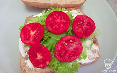 Выложите сверху нарезанный помидор.