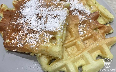 Посыпьте вафли сахарной пудрой перед подачей. Дополните малиной.