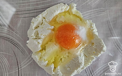 В отдельной емкости смешайте творог, яйцо, сахар по вкусу и ванилин. Аккуратно перемешайте до однородной консистенции. 