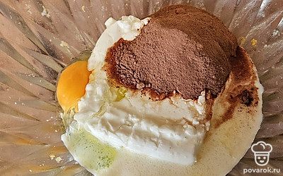 В отдельной емкости смешайте творог с яйцом. Добавьте какао и молоко. Тщательно перемешайте до однородной консистенции. 