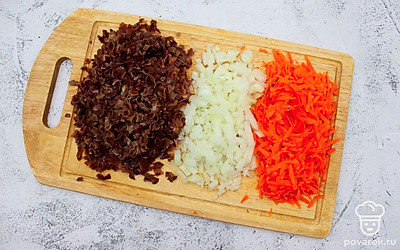 Под проточной водой промойте замоченные грибы, очищенные лук и морковь. Лук и грибы нарежьте небольшим кубиком. Морковь натрите на средней терке. 