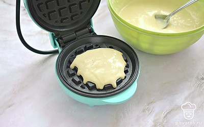 Включите электровафельницу и смажьте по необходимости панели растительным маслом. Когда вафельница хорошо прогреется, в центр нижней панели поместите 2 столовых ложки приготовленного теста.