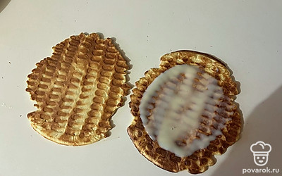 Две вафельки обильно смажьте сгущенным молоком и накройте оставшимися вафлями. 