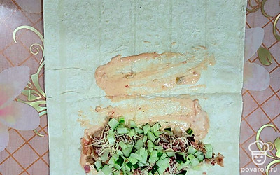 Выложите сверху мелко нарезанный огурец.