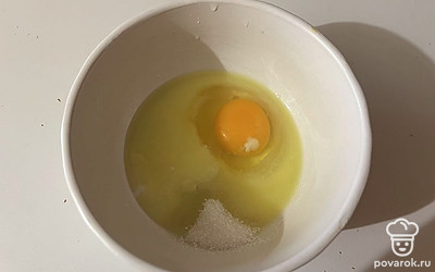 В пиалу разбейте яйцо и добавьте сахар. 