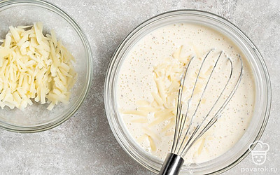 Вмешайте тертый сыр в тесто. Оставьте тесто на 10-15 минут при комнатной температуре. Оно должно быть в меру жидким и не пористым.