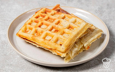 Выложите готовую вафлю на тарелку, а затем выложите новую порцию в вафельницу. Продолжайте жарить, пока не закончится тесто.