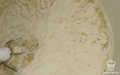 Понемногу засыпаем муку и взбиваем.