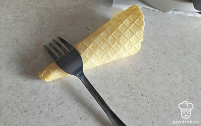Горячие вафли заворачиваем в конус и с помощью вилки фиксируем форму. Даем остыть.
