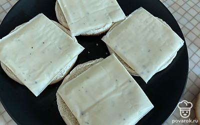 На нижнюю часть булочек выложите пластинки плавленого сыра. 