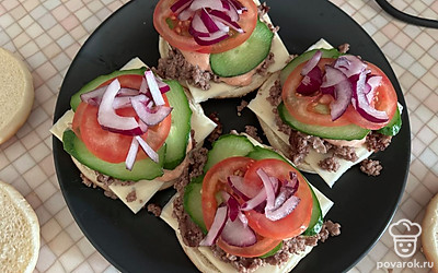 Поверх разместите нарезанные овощи. Всю начинку накройте верхними частями булочек. 