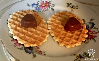 На вафельное печенье (можно использовать обычное песочное) кладем по кусочку шоколада. Отправляем в микроволновую печь.