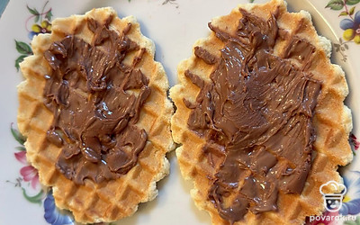 Следим, чтобы шоколад не перетопился и не растекся. Нам нужно лишь довести его до мягкости. Теперь горячей ложкой размазываем получившуюся шоколадную пасту по вафельке.