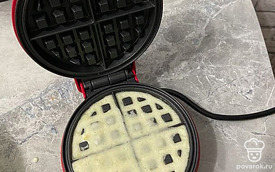 Смазать ячейки вафельницы маслом и залить туда 2 ложки полученного теста. 