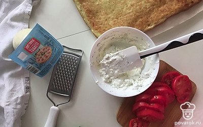 Выпекайте при 190 градусах 25 минут до золотистого цвета. Переверните корж на новый лист пергамента, дайте ему остыть. Помидоры нарежьте пластинками.