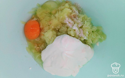 Очищенный кабачок натрите на крупной терке, выложите овощ в глубокую посуду и добавьте к нему куриное яйцо, соль, сметану и черный молотый перец по вкусу. Тщательно перемешайте массу и присоедините к ней ранее просеянную муку.