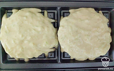 Электровафельницу промажьте растительным маслом, выложите в форму приготовленное кабачковое тесто и выпекайте вафли в течение 2-3 минут до румяности. Повторите аналогичные шаги со всем тестом.