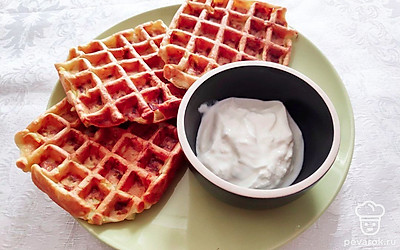 Нежные кабачковые вафли со сметаной подавайте в теплом виде, дополнив блюдо свежейте зеленью и овощами.