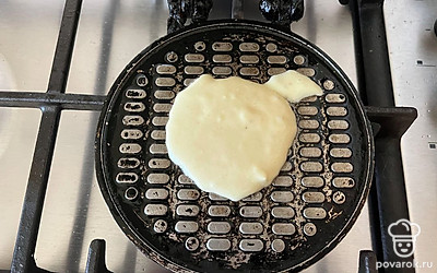 Вафельницу поставьте на огонь и порционно выложите смесь.