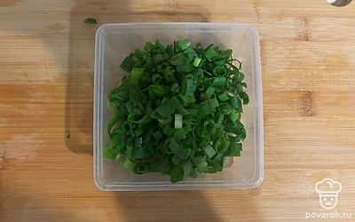 Нарезанный зеленый лук поместите в контейнер.