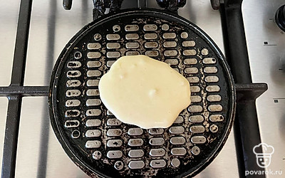 При помощи столовой ложки выложите на вафельницу порцию теста.