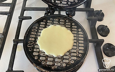 При помощи половника вылейте на форму часть теста. 