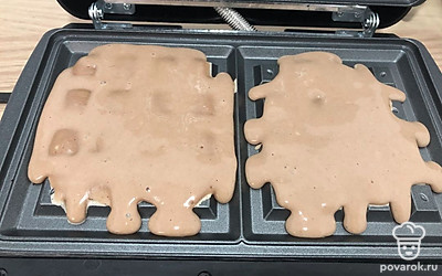 Получившееся тесто накладываем в вафельницу и ждём 10 минут. Готовые вафли выкладываем на тарелку. Блюдо готово.