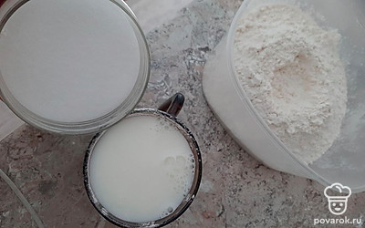 Не прекращая взбивать, добавьте сметану и влейте немного тёплое молоко, смешайте. В получившуюся смесь добавьте просеянную муку, разрыхлитель добавляйте с последней порцией муки.