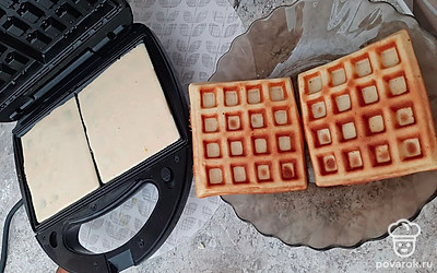 Панели вафельницы смажьте маслом, в каждую ячейку налейте по 2,5 столовой ложки теста, выпекайте вафли до золотистого цвета примерно 5-6 минут.