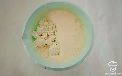 Сбавьте скорость миксера до минимальной. Постепенно введите в массу творог, муку, разрыхлитель, масло. Взбивайте тесто еще пару минут до однородности.