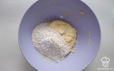 Возьмите перемешанный творог с яйцом и смешайте с просеянной с разрыхлителем муку.