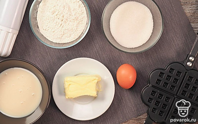 Для приготовления вафель в вафельнице на газу заранее достаньте масло из холодильника. Разделите его на кусочки и оставьте при комнатной температуре, пока оно не станет мягким. Белки отделите от желтков.