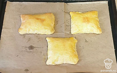 Слойки выложите на противень, застеленный пергаментной бумагой. Сверху смажьте желтком. Выпекайте в заранее разогретой духовке при 180 градусах 25-30 минут в режиме «верх-низ».