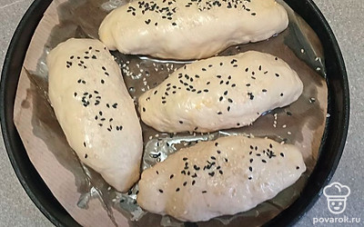 Посыпьте пирожки кунжутом и поставьте в разогретую духовку.