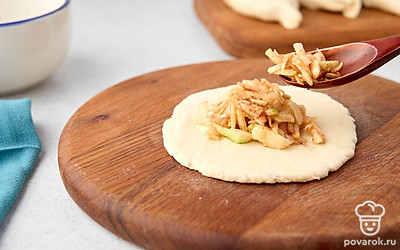 Разделите тесто на несколько частей. Раскатайте каждую в небольшую круглую лепешку. Выложите в центр каждой лепешки яблочную начинку.