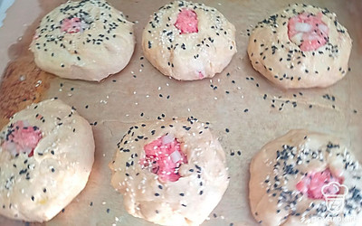 Смажьте пирожки яйцом, посыпьте черным и белым кунжутом. Поставьте в разогретую духовку.