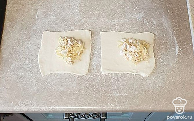Тесто слегка раскатайте и разрежьте на квадратики. Начинку выложите на тесто, соедините края в центре, хорошо защипните.