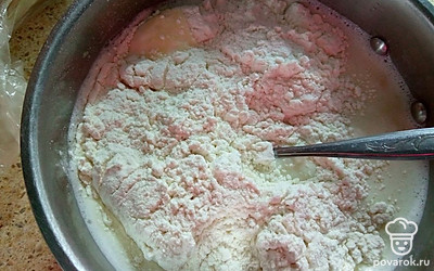 Влейте молоко и снова перемешайте. Порционно добавляйте просеянную муку. Перемешивайте до однородности. Тесто должно получиться как жидкая сметана.