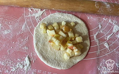 В центр раскатанного теста выложите столовую ложку яблочной начинки. 