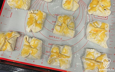 Делаем конвертик и выкладываем на противень. Смазываем яичным желтком каждый пирожок, для румянца.