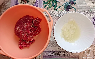 Делаем начинку для беляшей. В фарш выкладываем измельченный на терке лук, соль и перец. Перемешиваем.